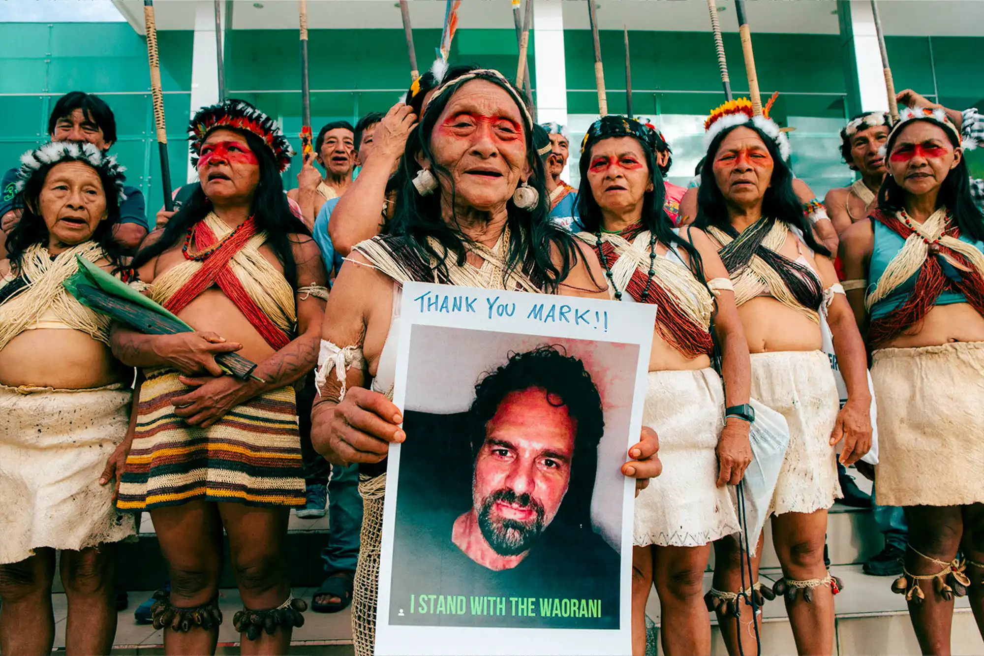 Waorani woman holding a sign featuring actor and activist Mark Ruffalo, who expressed his support for the “The Amazon Is Not For Sale” campaign. Photo: Amazon Frontlines.
